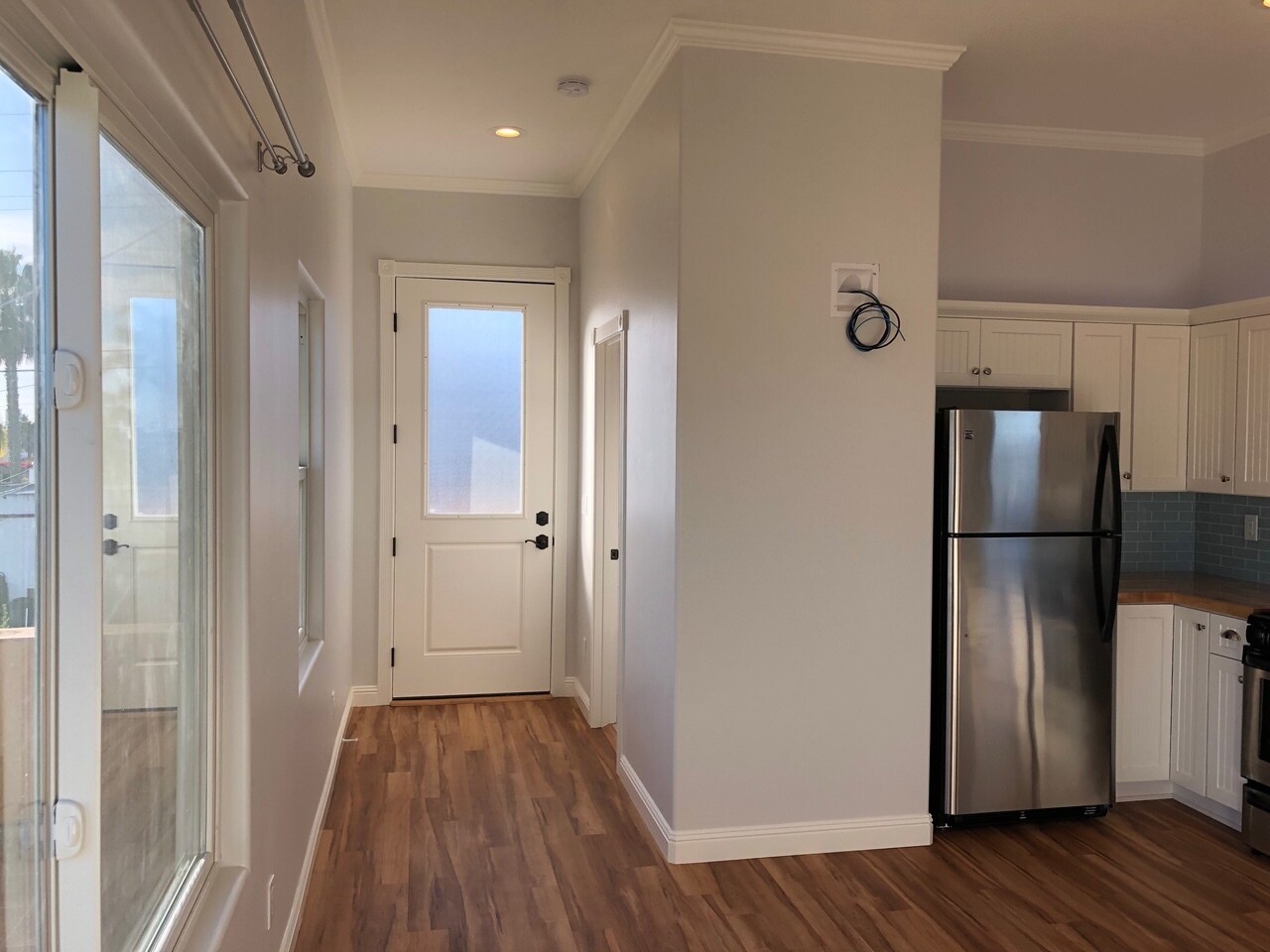 Front door 8-feet tall, front hallway with bathroom and laundry door. - 4470 Swift Ave