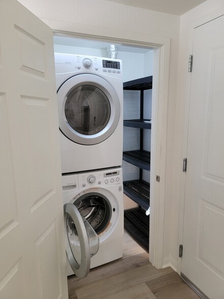 LG stacked washer and dryer inside closet with a rack - 12655 Bluff Creek Dr