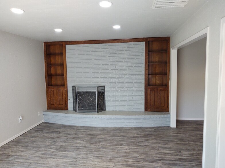Living Room with fireplace and built in book shelves and cabinet storage - 7126 NW 116th St