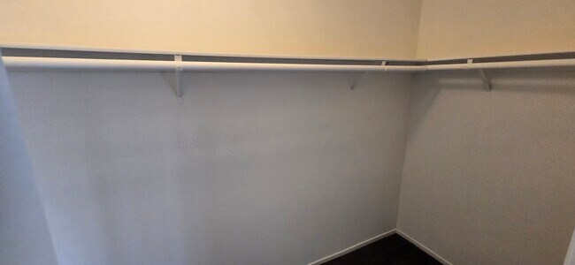 Walk-in closet with wrap around shelving and hanger rods - 14365 Foothill Blvd