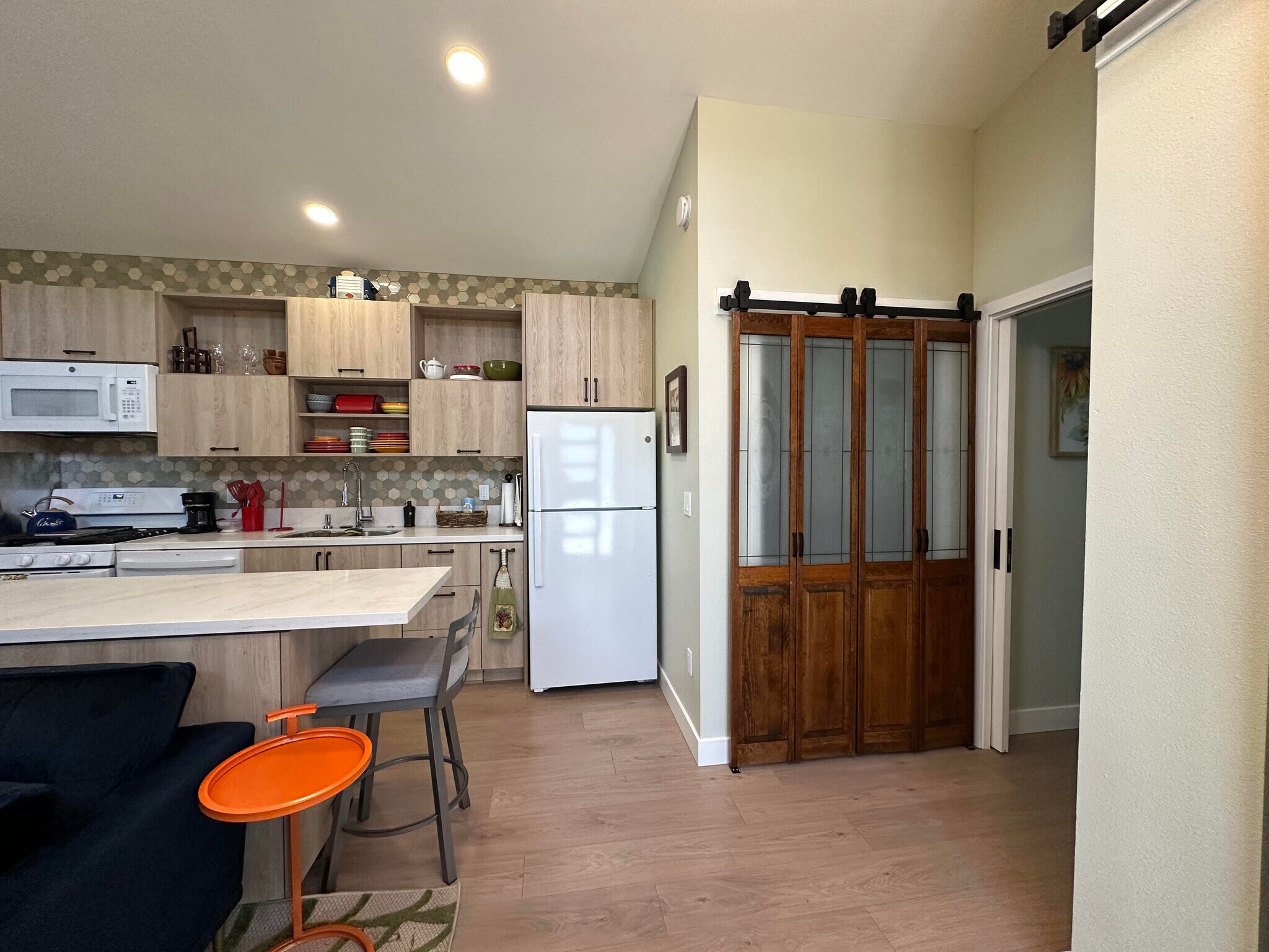 view of kitchen from the front door, dark wood closet doors have full-sized washer and dryer behind - 1490 Ash St