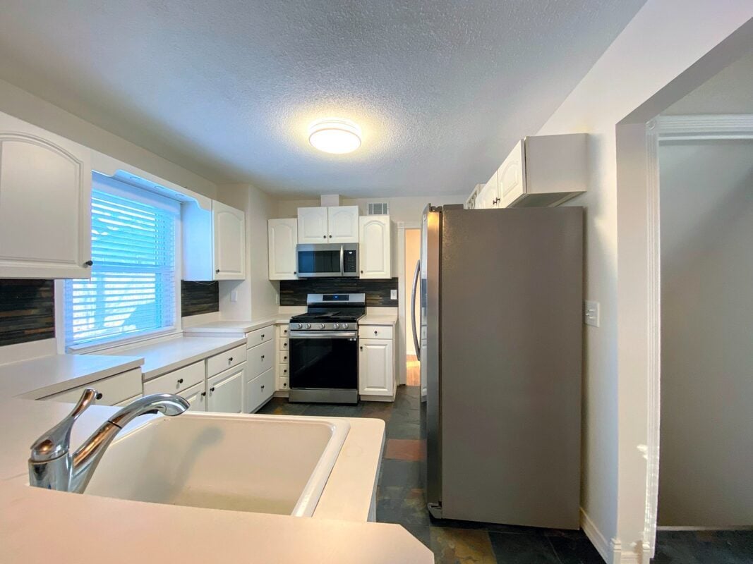 Kitchen - Gas range with vented hood fan, dishwasher, and refrigerator - 710 Sheridan Avenue North