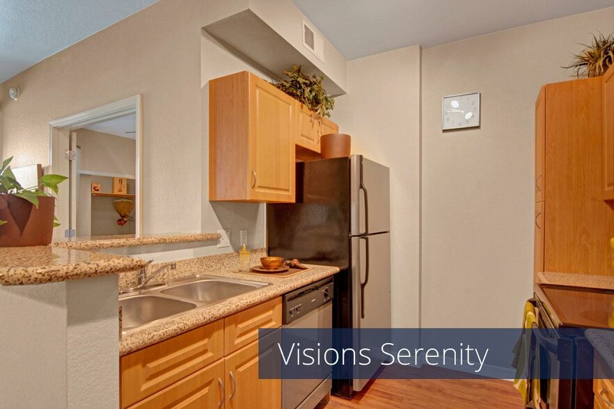 A kitchen with light cabinets and black appliances - Visions