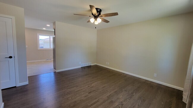 Large Living Room with refinished hardwood floors through the first floor. New ceiling fan & drapes - 6305 49th Ave