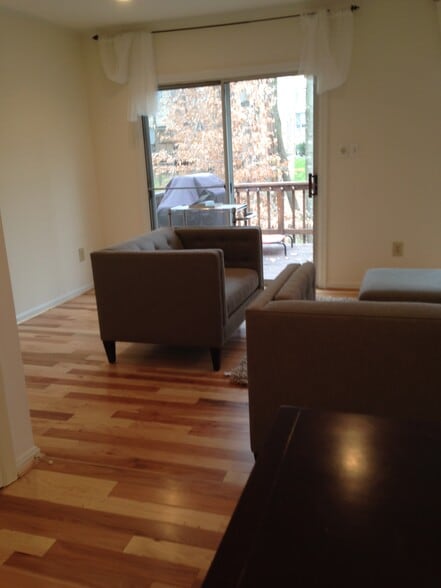 Open floor plan, with kitchen open to dining and living rooms, view onto deck and woods - 10651 Pine Haven Ter