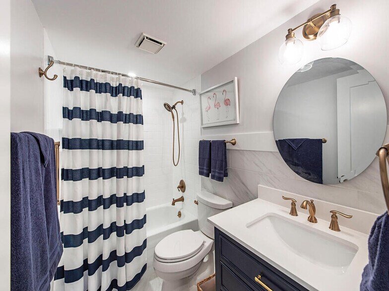 Guest bath with nautical brass finishes - 555 Park Shore Dr