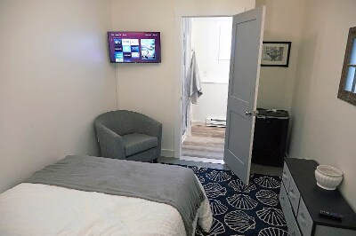 Bedroom with "en suite" bathroom, additional storage drawers, comfy chair, and 32 in Smart TV. - 9 May St