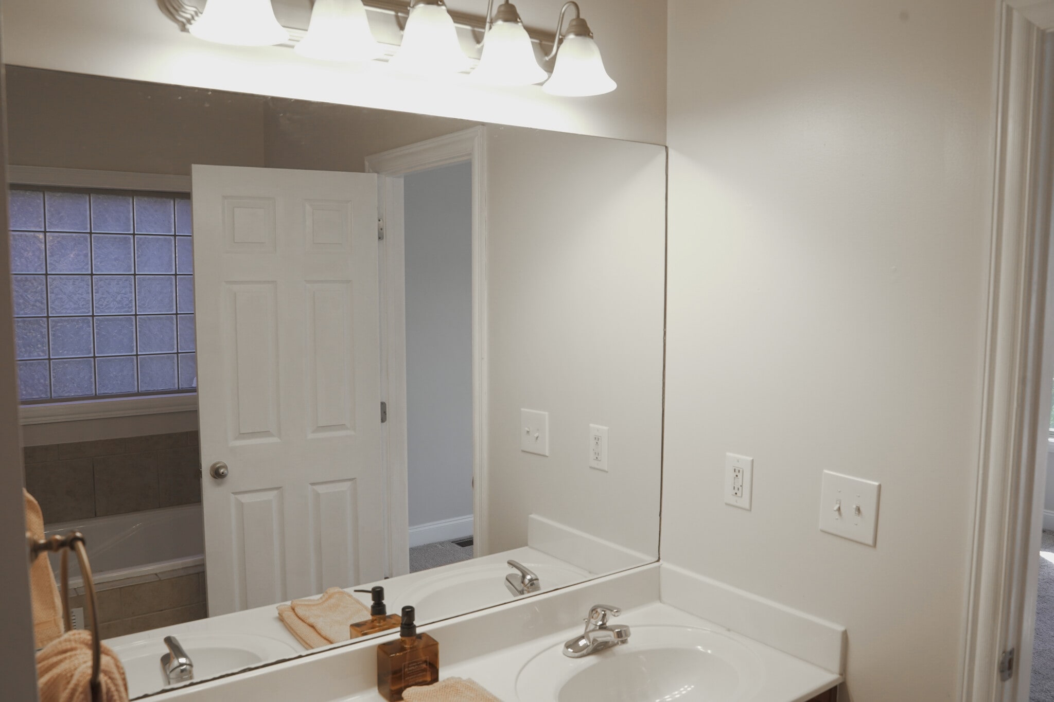 Primary Bath with glass tiled window in mirror reflection and Jet tub underneath. (9x8) - 393 Hays Blvd