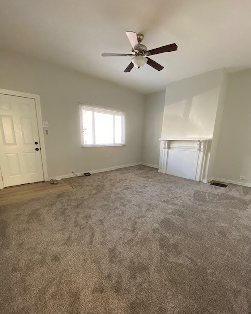 Large living room with new carpeting and new ceiling fan - 5234 Holmes St