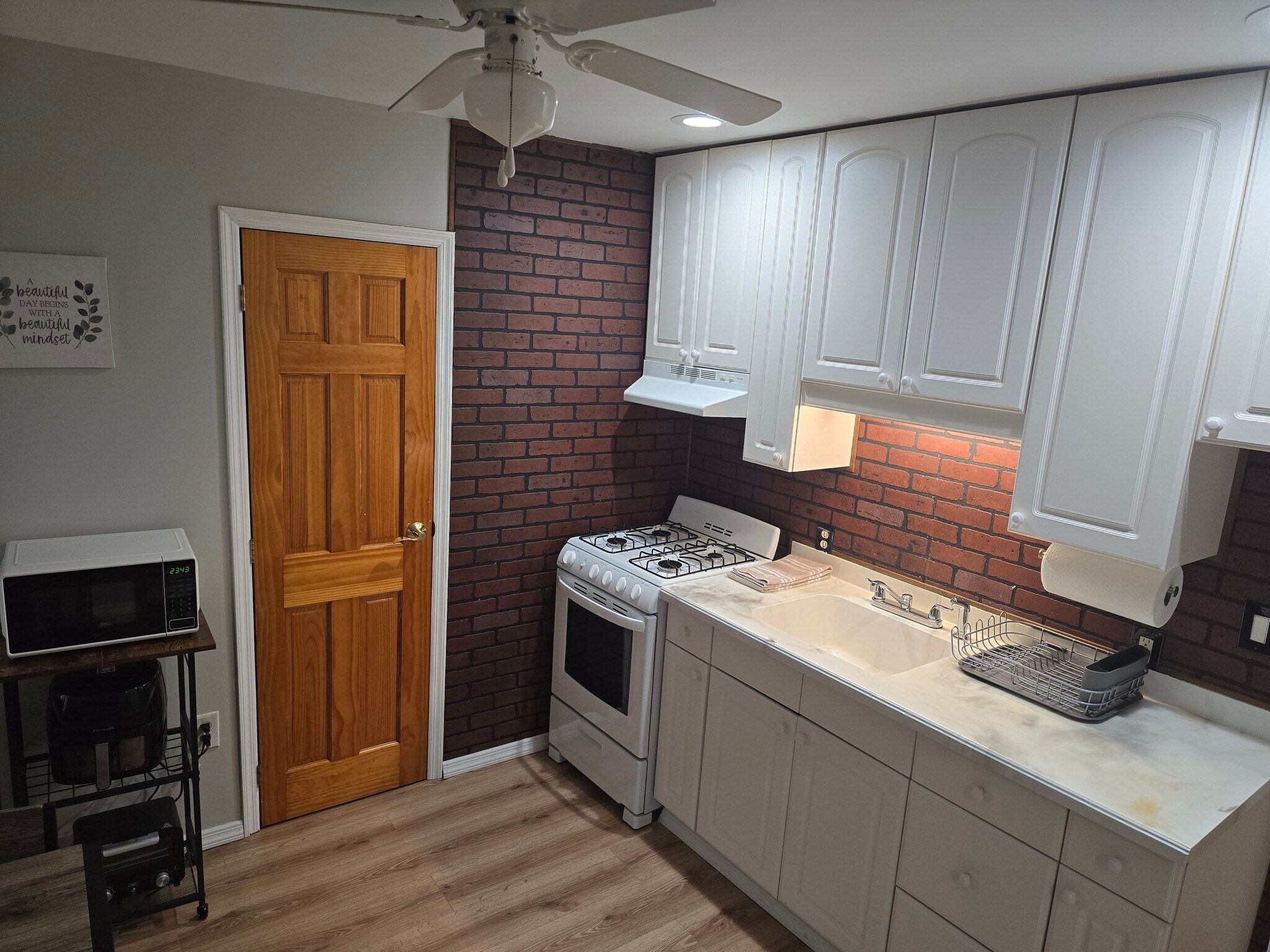 View of kitchen sink area, stove/oven, spacious cabinets and doorway to bathroom - 510 North St