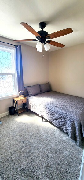 Secondary bedroom featuring a Queen bed, blackout curtains, wireless phone charger and sound machine - 822 E 4th St
