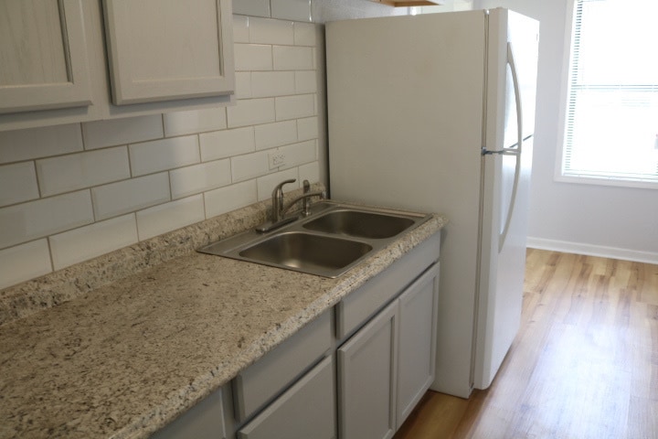 Kitchen with countertops, cabinets, beveled edge backsplash, sink and refrigerator. - 1439 N Olympia Ave