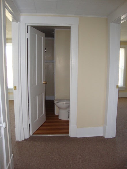 Hall. Bedroom doors on sides, bathroom ahead. - 225 College Ave