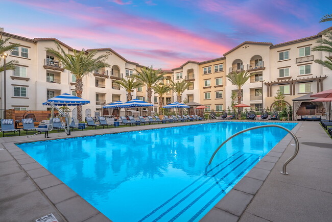 Resort-style pool with lounge seating and personal cabanas with TV’s. - LIVIA at Scripps Ranch