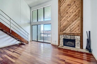 Living room with vaulted ceilings, high windows, balcony door, mountain views, and fireplace - 14282 E Tufts Pl