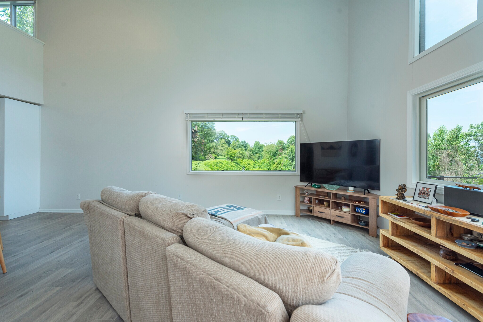 Sun-drenched entertainment space anchored by large picture windows looking out onto lush green. - 405 Windswept Dr