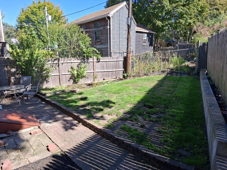The shared back yard is fully fenced-in and has a seating area. - 13 Mulberry St