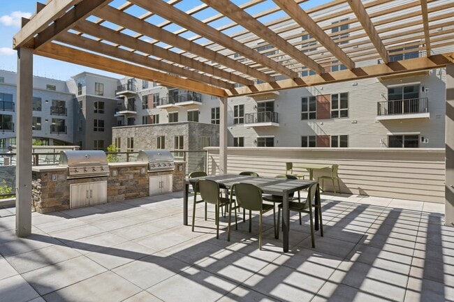 Outdoor courtyard with grilling and dining area. - Modera Newton