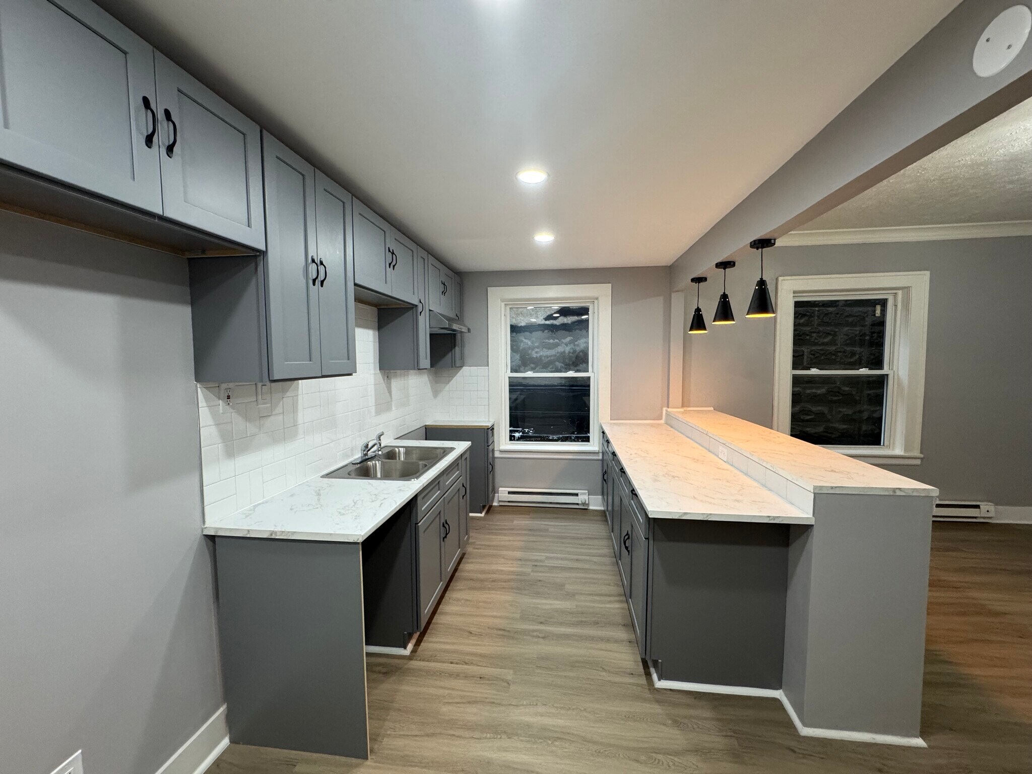 Stylish gray cabinetry, marble-look counters, and updated lighting. - 898-902 Portland Ave