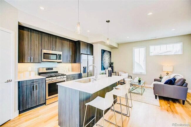 Explore this inviting open-concept kitchen and living space, perfect for modern living. - Harley House