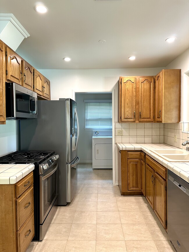 Kitchen with stainless appliances and access to laundry, pantry, bedroom and back door. - 5182 Woodley Ave