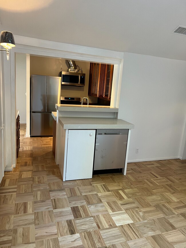 View of kitchen from dining room with dishwasher in cabinet. - 2021 Rosilla Pl