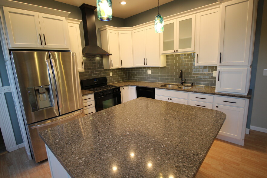 Gorgeous updated kitchen boasting quartz countertop, massive island w/seating, tile, extra tall cabs - 4536 Leo Street