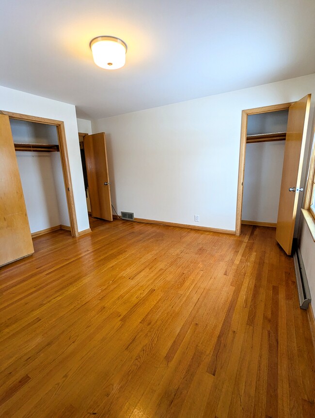 The master bedroom features two closets and original hardwood floors. - 910 Maple St