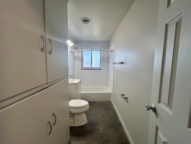 Bright and spacious bathroom featuring a sleek white design, modern fixtures, and ample storage space. - Boardwalk Apartments