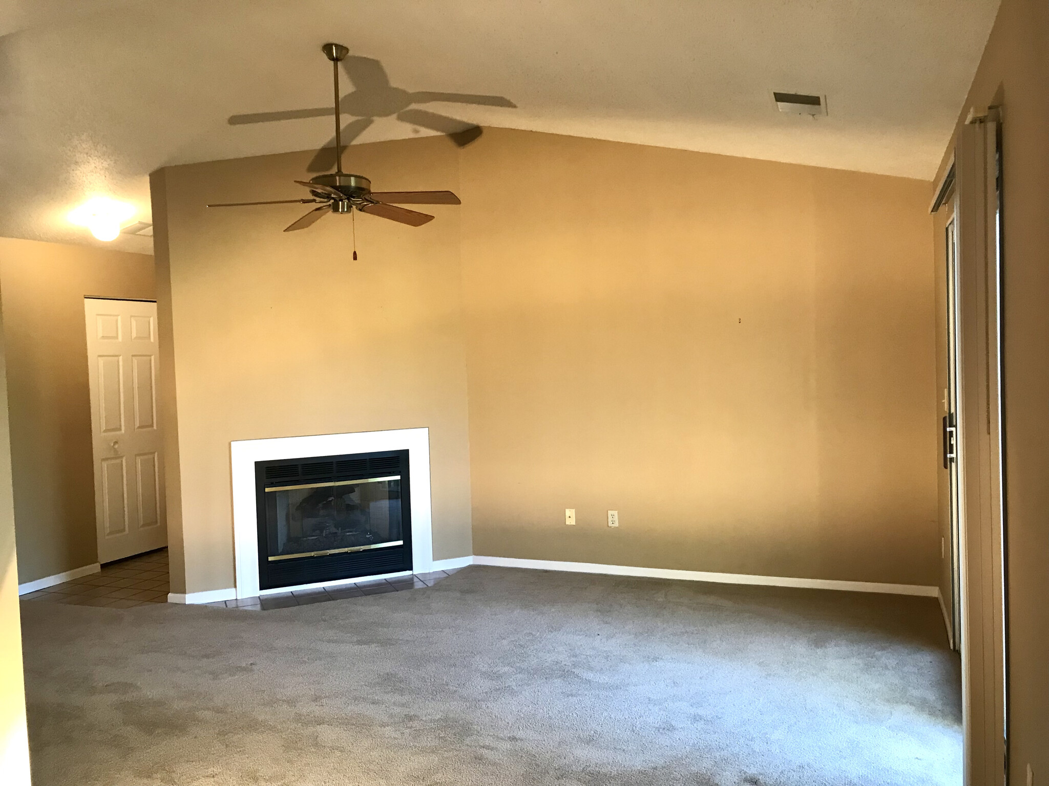 Main living space with gas fireplace, vaulted ceiling and ceiling fan - 3173 Windcrest Dr NE