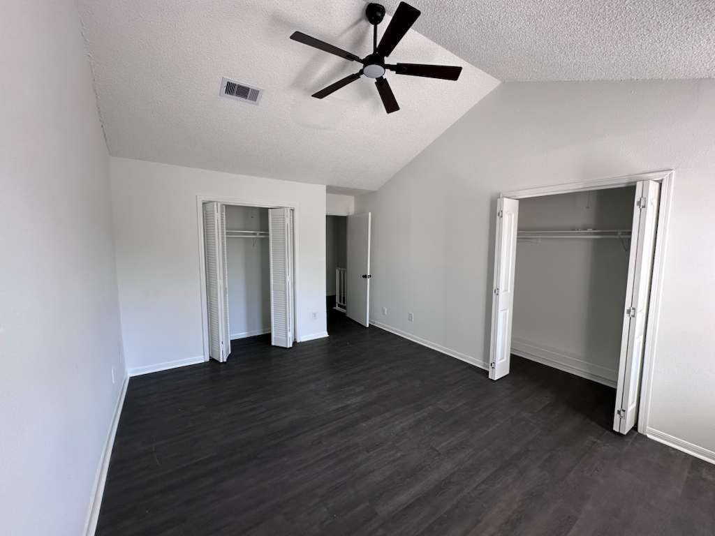 Spacious primary bedroom featuring brand-new ceiling fans, lighting, and double closets - 7700 Creekbend Dr