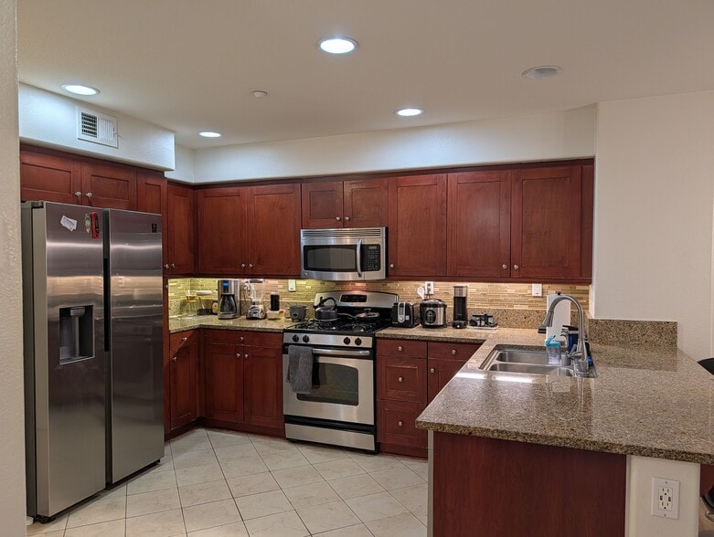 Kitchen with refrigerator, freezer, washing machine, stove and microwave. - 3542 Shoreline Bluff Lane