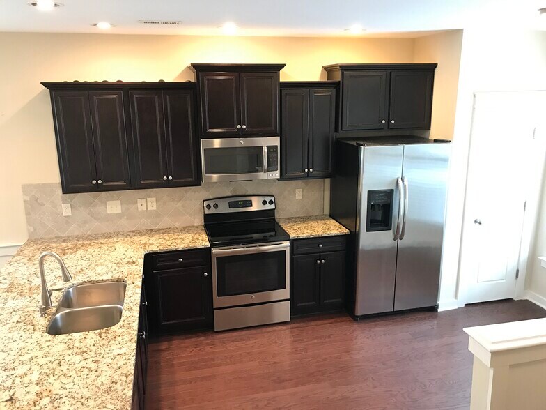 Kitchen with granite countertops, tile backsplash and stainless steel appliances - 6417 Swatner Drive