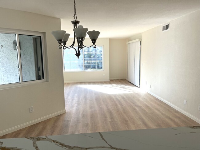 View through dining area into living space. New flooring throughout unit. - 1249 Mission Verde Dr