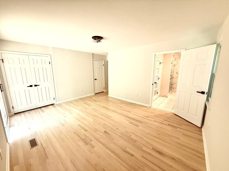 Main floor primary bedroom with private bath and walk-in - 9248 Wood Glade Dr