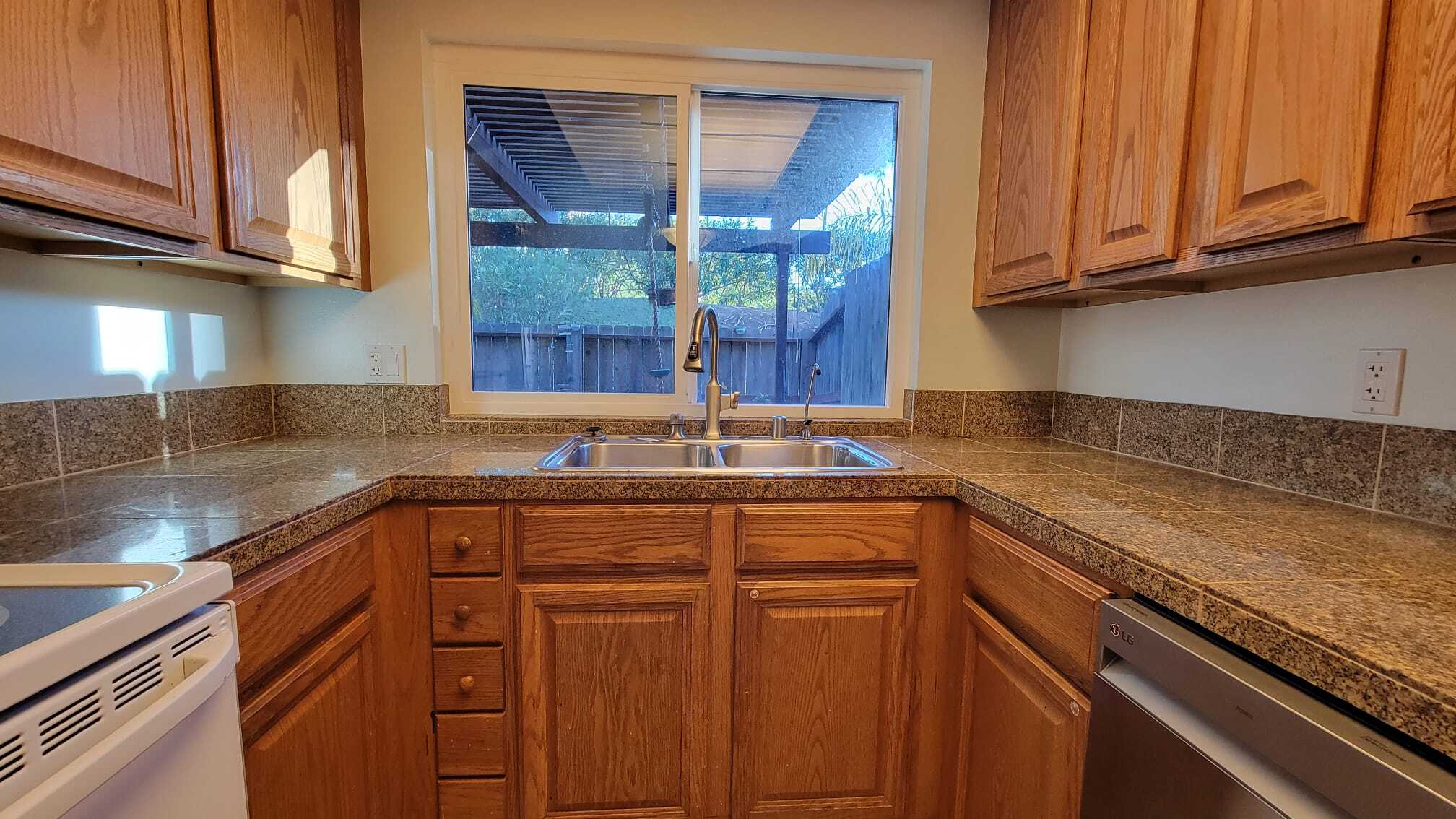 The kitchen overlooks the patio. There is a ledge right outside the window for plants and flowers. - 9505 Easter Way