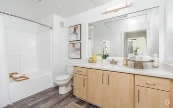 Modern Bathroom with Light Wood Vanity and Large Mirror - Villas at the Gardens