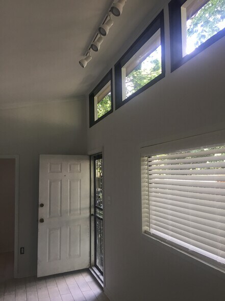 Black-trimmed sky windows, track lighting, and 2" faux wood blinds. Front door to yard - 1742 N Parkway