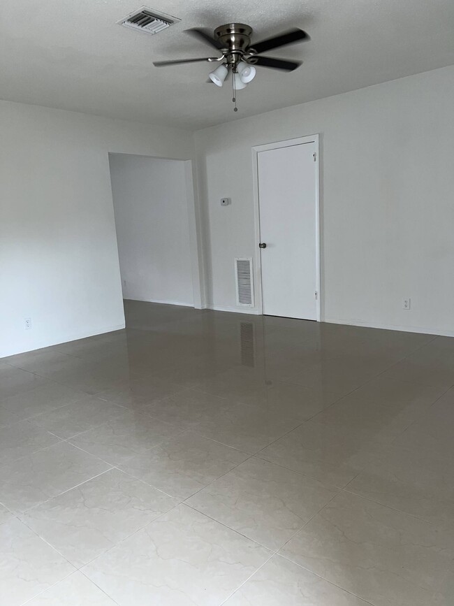 Living room: porcelain floors throughout. Ceiling fan in living room and two bedrooms. - 5010 SW 26th Ave