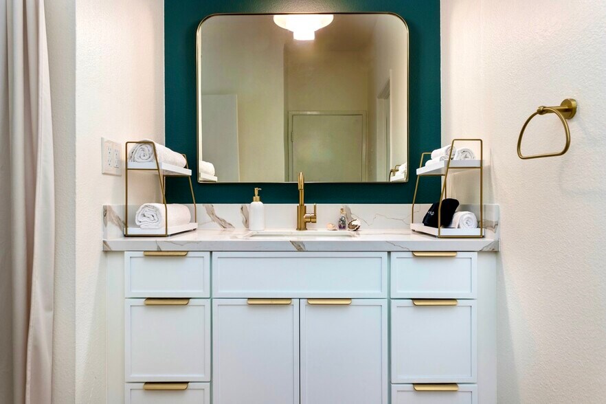 Modern vanity with marble countertop, gold fixtures, and designer lighting - 2221 Ocean Ave