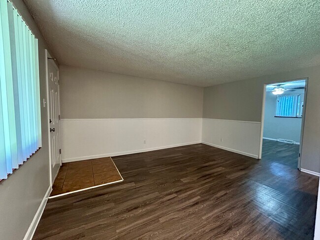 Inviting living area with elegant wood flooring and ample natural light. - Boardwalk Apartments