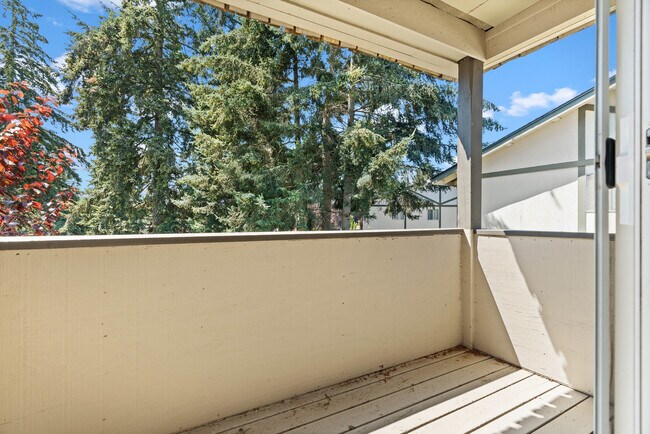 Unwind on your private balcony with a stunning view of nature's beauty. - University Crossing Apartments