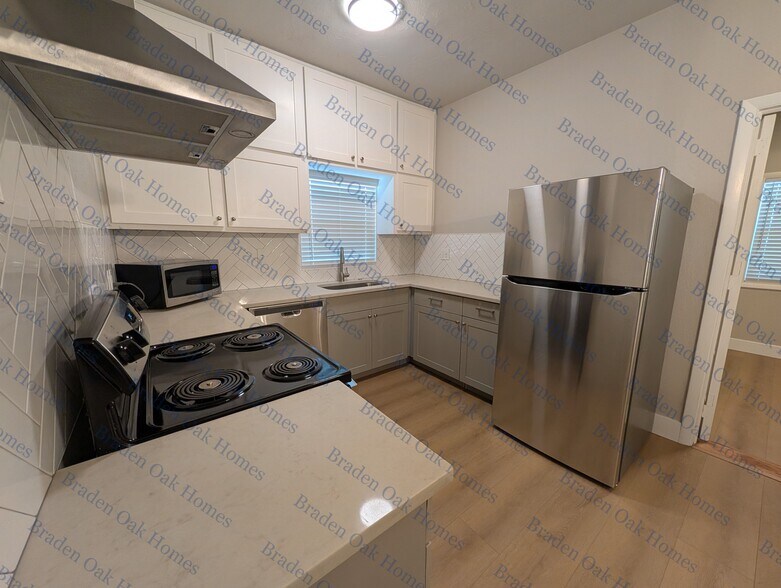 Kitchen with stainless steel appliances and quartz countertops - 2608 19th Ave W