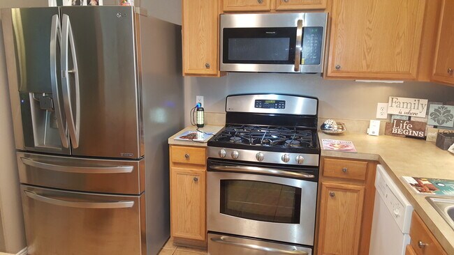 Kitchen:10X10, Natural wood kitchen cabinetry with decorative knobs. Under-cabinet night light. New French 4 doors Stainless steel Refrigerator. Window drapes/blinds. Dishwasher, Ceiling fans, spacious kitchen with lots of cabinets - 23619 Twisting Falls Drive