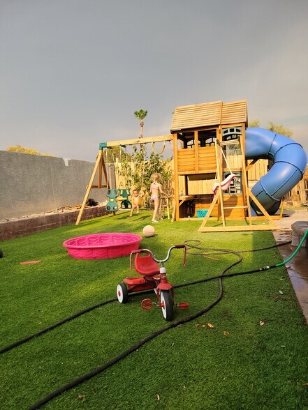 Turf backyard with patio covered patio and playhouse - 3114 E Oquendo Rd
