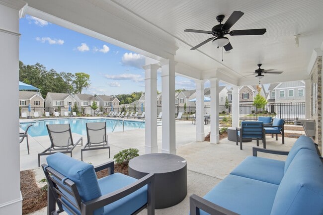 Covered poolside lounge with elegant seating. - West Oak Trace
