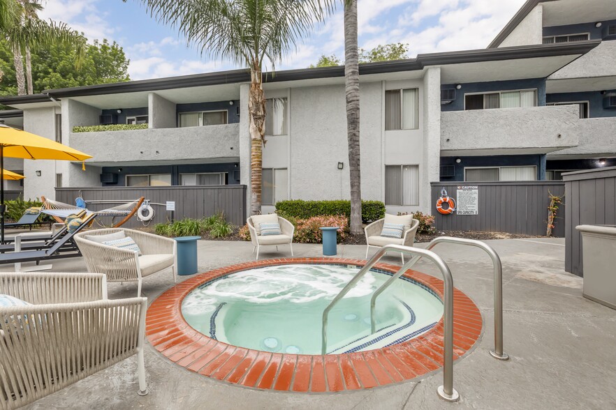 Relaxation oasis: Dive into luxury at Cornerstone Apartments, where every dip in our updated pool and hot tub is a retreat under the palms. - Cornerstone Apartment Homes