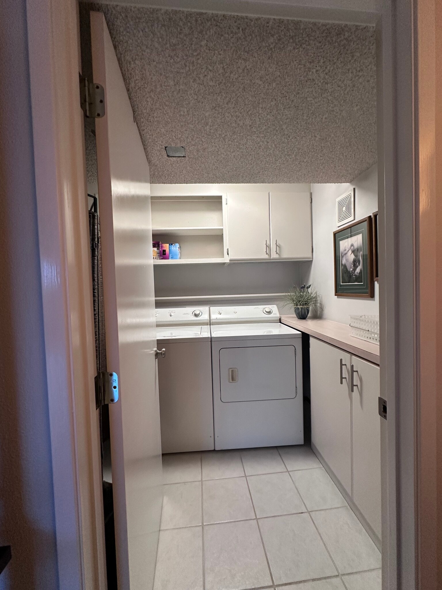 Laundry room with storage cabinets and shelves. - 4439 54th Ave SW