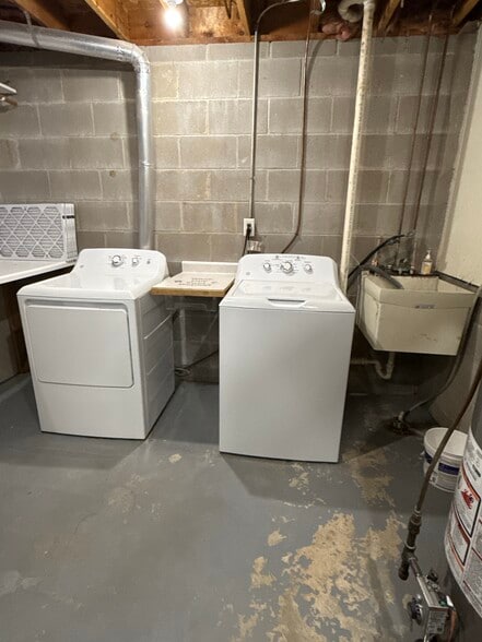 Laundry area with washer, dryer, and utility sink. - 9092 Goldenrod Ln N