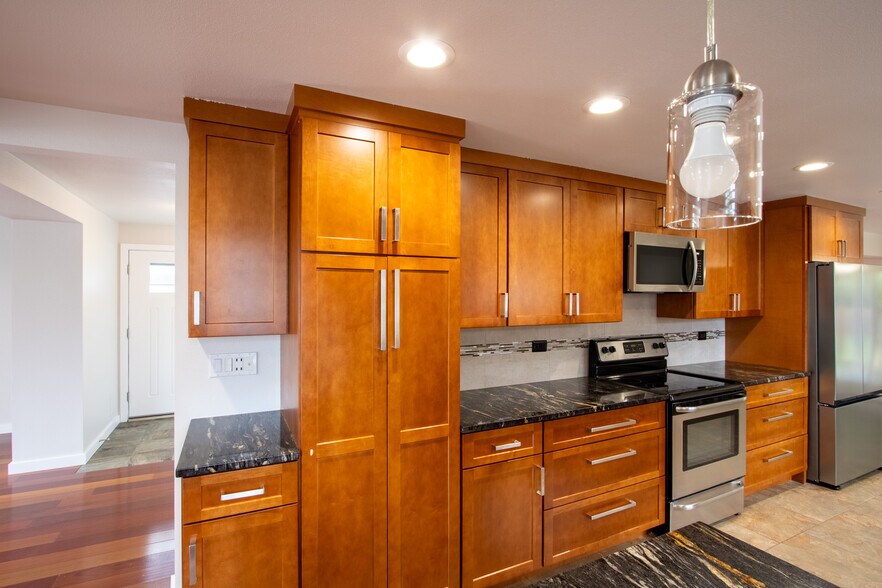 Kitchen - stone counters, stainless appliances, tile floor, pantry - 13234 SE 261st St